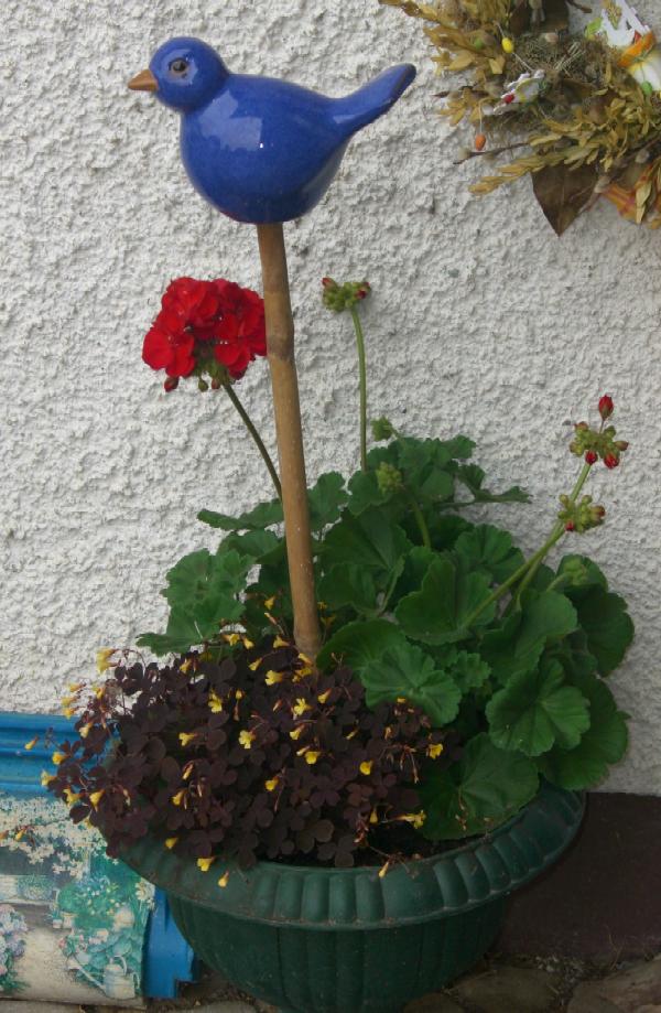 Blumenspindel mit roter Geranie auch im Hof